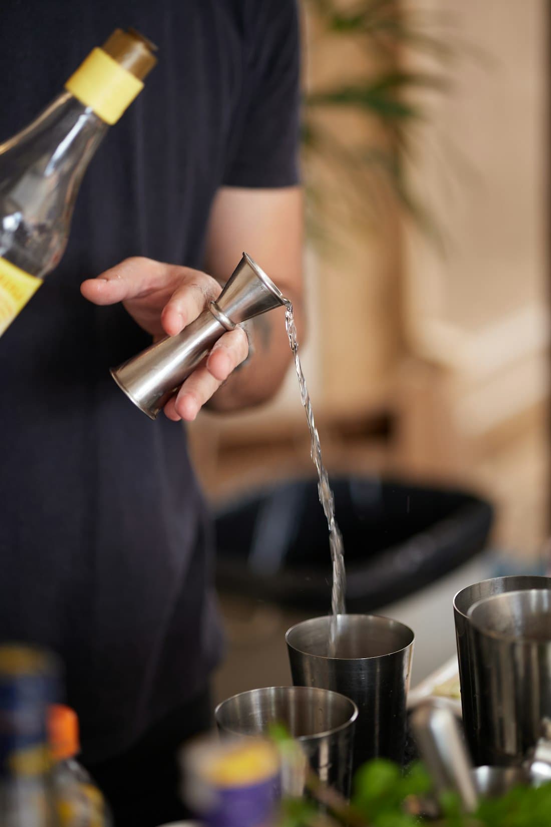 Bartender measuring a spirit into a jigger
