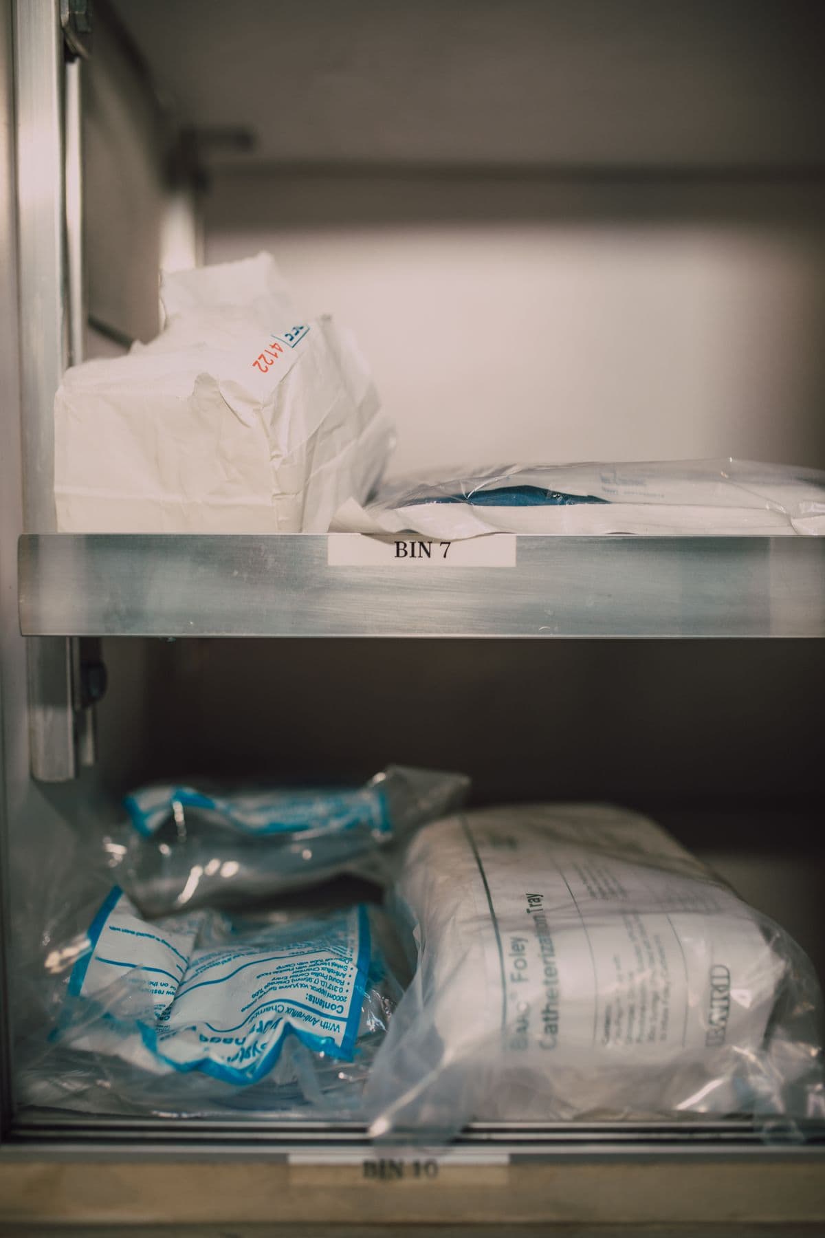 Packaged clinical supplies arranged in labeled storage bins